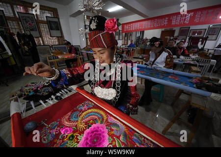 Chinesische Frau Liu Ying von Miao ethnische Gruppe schafft ein Kunstwerk von Miao Stickerei an Ihre Werkstatt in Kaili Stadt, im Südwesten Chinas Provinz Guizhou, 9. Stockfoto