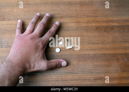 Männliche hand von Biene gestochen und Medikamente für Sie Schwellungen. Hand, Schwellungen, Entzündungen, Hautrötungen sind Anzeichen einer Infektion. Insekt beißt und Pillen auf t Stockfoto