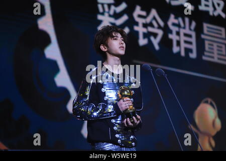 Sänger und Rapper Cai Xukun von chinesischer Junge Gruppe neun Prozent mit der Trophäe für den "Besten Rückruf Musik verkaufen Sänger' Award an der 12 Mig wirft Stockfoto
