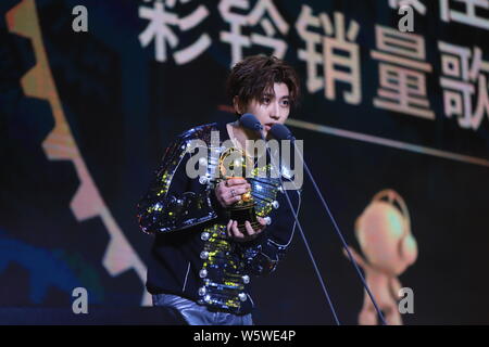 Sänger und Rapper Cai Xukun von chinesischer Junge Gruppe neun Prozent mit der Trophäe für den "Besten Rückruf Musik verkaufen Sänger' Award an der 12 Mig wirft Stockfoto