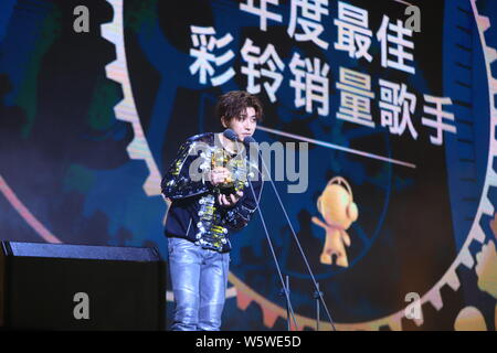 Sänger und Rapper Cai Xukun von chinesischer Junge Gruppe neun Prozent mit der Trophäe für den "Besten Rückruf Musik verkaufen Sänger' Award an der 12 Mig wirft Stockfoto