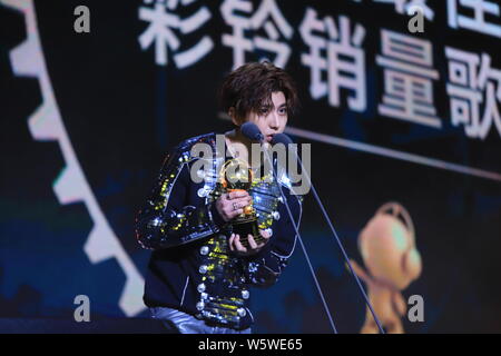 Sänger und Rapper Cai Xukun von chinesischer Junge Gruppe neun Prozent mit der Trophäe für den "Besten Rückruf Musik verkaufen Sänger' Award an der 12 Mig wirft Stockfoto