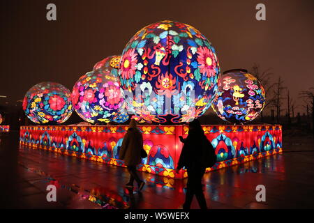 Fußgänger vorbei eine bunte und beleuchtete Kunst Installation mit der Form der traditionellen chinesischen Elementen kommende neue Jahr r zu kennzeichnen Stockfoto