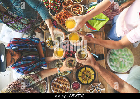 Toast mit Freund Abendessen auf der Terrasse zu genießen. Sommer Aperitif mit Freunden. Freude und Festlichkeiten in der Familie Ansicht von oben Stockfoto