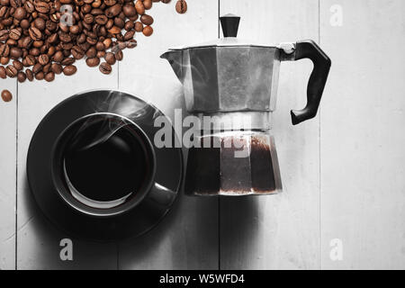 Vintage verwendet Italienischen moka Kanne lag auf weiße Holztisch in der Nähe von Schwarzen Schale und Kaffeebohnen, Ansicht von oben Stockfoto