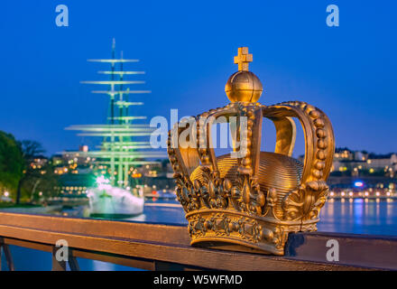 Goldene Krone auf Skeppsholm Brücke mit beleuchteten Stockholmer Altstadt Stockfoto