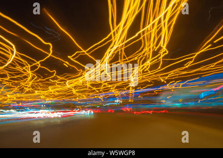 Verschwommen defokussierten Lichter von dichtem Verkehr auf einem nassen Regnerisch. Ampel in Bewegungsunschärfe. Stockfoto