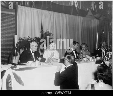 Foto des ehemaligen Präsidenten Harry S. Truman Gruß ein Bewunderer während der Eröffnungs-Jubiläum Abendessen im National Guard Armory in Washington; er ist neben der First Lady Jacqueline Bouvier Kennedy und Attorney General Robert F. Kennedy sitzt. Stockfoto