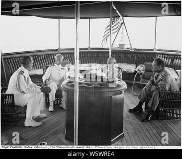 Foto während der Ferien Kreuzfahrt von Präsident Harry S. Truman nach Bermuda. Auf der fantail der US S. Williamsburg, L bis R: Kapitän James Foskett, Adm. Sir Irvine Glennie, Präsident Truman, und Gen. Harry Vaughan. Stockfoto