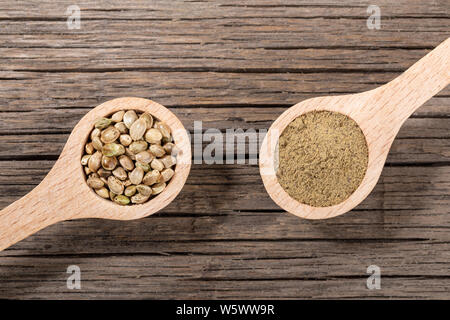 Zwei Kochlöffel mit Cannabis Getreide und Mehl auf alten Risse im Holz. Superfood Konzept. Ansicht von oben, flach. Stockfoto