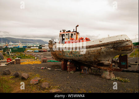 Eine alte verlassene Fischerboot in sehr schlechtem Zustand für eine Wiederherstellung am Ufer neben einer alten Werft in Reykjavik. Stockfoto