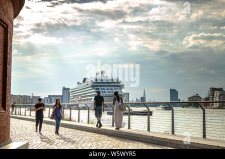 Touristen durch die Themse mit MV Viking Sky Kreuzfahrt Schiff im Hintergrund in Greenwich, London Stockfoto