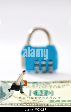 Miniatur Menschen: Unternehmer gehen auf Geld mit Key Lock unscharfen Hintergrund (dieses Bild für die Sicherheit auf finanzielle und geschäftliche Konzept) Stockfoto