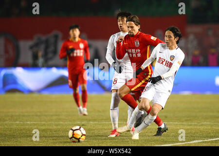 Dänischer Fußballspieler Lasse Vibe, Mitte, Changchun Yatai den Ball gegen Spieler von Tianjin Quanjian in der 29. Runde während des 2. Stockfoto