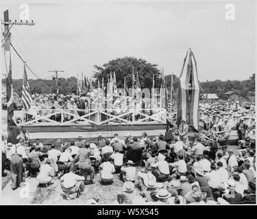 Präsident Harry S. Truman, Präsident Romulo Gallegos von Venezuela, und andere Würdenträger auf der Überprüfung der Plattform, Bolivar, Missouri. Eine Masse umgibt die Plattform, und drapierte Statue von Simon Bolivar steht neben ihm. Präsident Truman die Statue gewidmet. Stockfoto