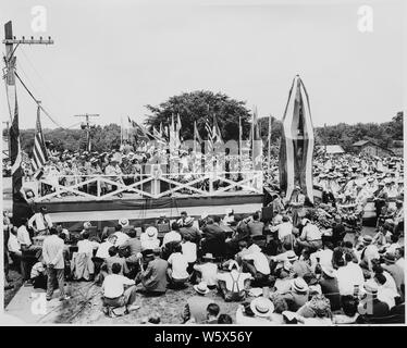 Präsident Harry S. Truman, Präsident Romulo Gallegos von Venezuela, und andere Würdenträger auf der Überprüfung der Plattform bei Bolivar, Missouri. Eine Masse ist um die Plattform versammelt, und drapierte Statue von Simon Bolivar ist auf der rechten Seite. Präsident Truman die Statue gewidmet. Ein unbekannter Mann spricht. Stockfoto