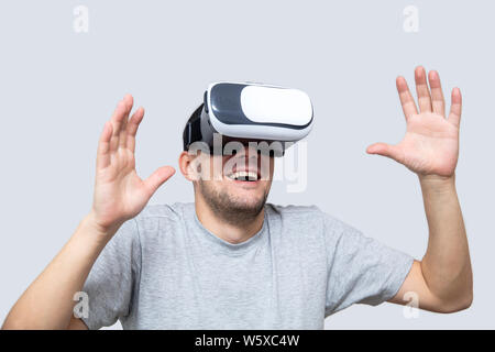 Junger Mann mit VR-Headset im Studio, erleben virtuelle Realität Stockfoto