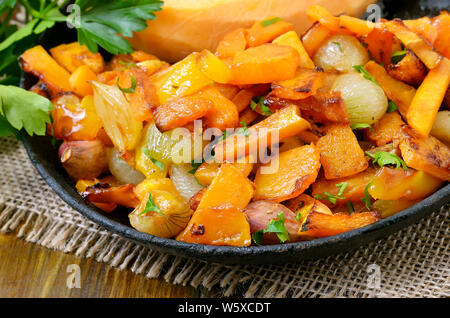 Gebratener Kürbis, Zwiebel, Knoblauch und Pfeffer in der Pfanne, Ansicht schließen Stockfoto