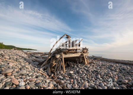 Driftwood Tierheim und glatte, runde Steine am See Superior Shoreline bei Marathon, Ontario. Stockfoto