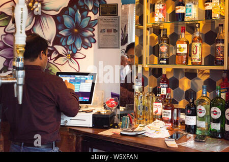 Doncaster, Großbritannien - 11 Mai 2019: der Besitzer des Restaurants taps Einträge in die Kasse, in der Bar Spiegel an La Boca steakhouse wider am Samstag, den 11. Mai an Stockfoto