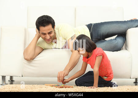 Mann mit seiner Tochter zu Hause Mancala-Spiel zu spielen Stockfoto