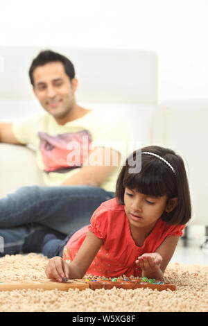 Mädchen spielen Mancala-Spiel zu Hause Stockfoto