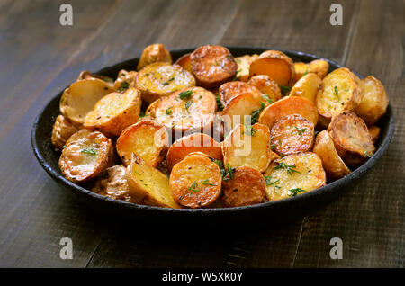 Gebratene Kartoffeln in einer Pfanne auf hölzernen Hintergrund Stockfoto