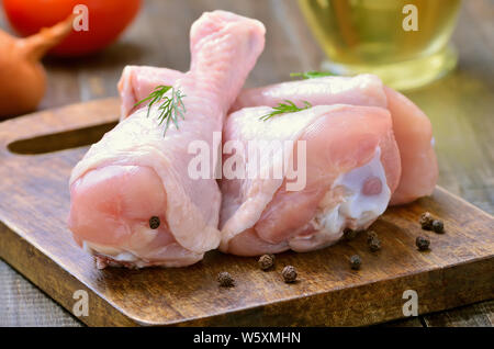 Raw Chicken Drumsticks und Gewürzen auf Holz Schneidebrett Stockfoto