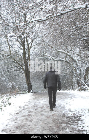 Aufrechte Menschen in Schwarz gekleidet in verschneiten Wäldern Stockfoto