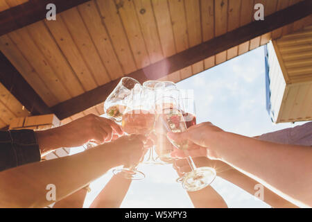 Menschliche Hände mit Gläser Rotwein zu klirren über serviert. Stockfoto