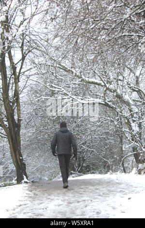 Aufrechte Menschen in Schwarz gekleidet in verschneiten Wäldern Stockfoto