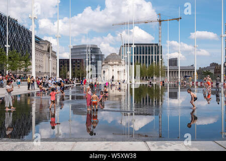 Kinder spielen und Abkühlen in den neuen Wasserspiel Spiegel und Brunnen in Centenary Square, Birmingham an einem heißen Tag Stockfoto