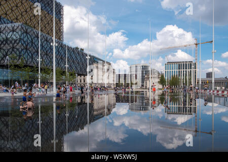 Kinder spielen und Abkühlen in den neuen Wasserspiel Spiegel und Brunnen in Centenary Square, Birmingham an einem heißen Tag Stockfoto