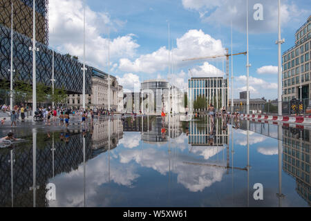 Kinder spielen und Abkühlen in den neuen Wasserspiel Spiegel und Brunnen in Centenary Square, Birmingham an einem heißen Tag Stockfoto