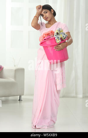 Frau mit Eimer und Stirn abwischen Stockfoto