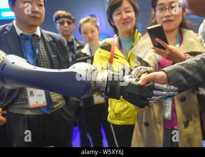 Eine Schunk 5-Finger greifen Hand (SVH) für Serviceroboter entwickelt, schüttelt Hände mit einem Besucher während der ersten China International Import Expo (CIIE 2 Stockfoto