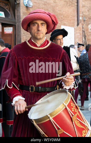 Mann gekleidet in mittelalterlichen Gewandungen und Kostüme spielt die Drums während der Palio in Siena, Italien Stockfoto