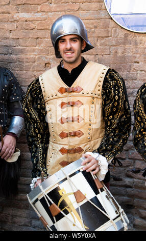 Ein junger Mann im Mittelalter Gewandung und Kostüme spielt die Drums während der Palio in Siena, Italien Stockfoto