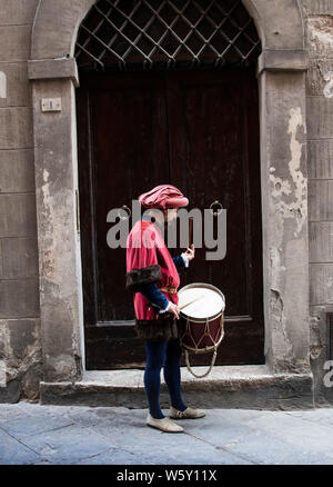 Ein junger Mann im Mittelalter Gewandung und Kostüme spielt die Drums während der Palio in Siena, Italien Stockfoto