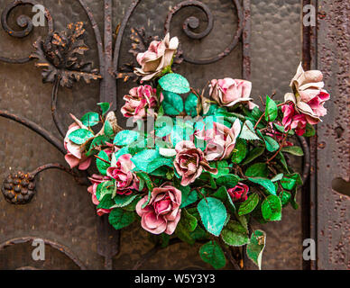 Verwitterter Blumenstrauß vor der rostigen Tür auf dem Friedhof Père Lachaise, Paris Stockfoto