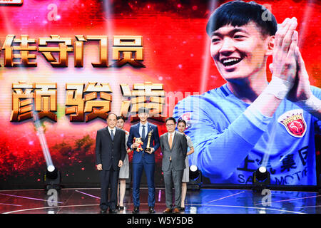 Chinesische Fußballspieler Yan Junling, Center, Shanghai SIPG wirft mit seiner Trophäe, nachdem er den besten Torwart Award 2018 Chinesische Su Stockfoto