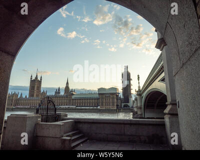 Parlamentsgebäude von einem Torbogen am Südufer der Themse mit Wsetminster Bridge auf der rechten Seite, London. Stockfoto