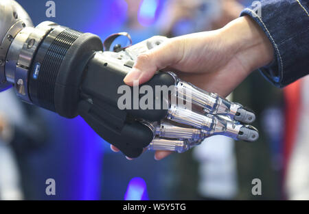 Eine Schunk 5-Finger greifen Hand (SVH) für Serviceroboter entwickelt, schüttelt Hände mit einem Besucher während der ersten China International Import Expo (CIIE 2 Stockfoto