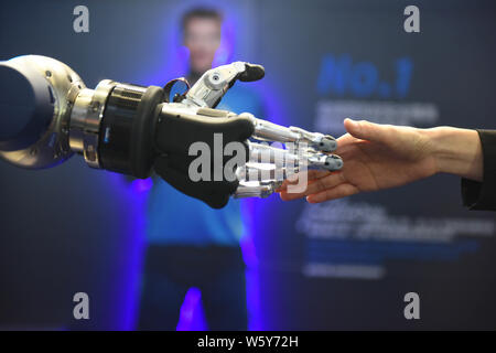 Eine Schunk 5-Finger greifen Hand (SVH) für Serviceroboter entwickelt, schüttelt Hände mit einem Besucher während der ersten China International Import Expo (CIIE 2 Stockfoto