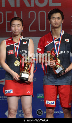 Arisa Higashino, Links, und Yuta Watanabe von Japan stellen mit ihren Trophäen auf dem Podium nach dem Sieg über Wang Yilyu und Huang Dongping Chinas in der Stockfoto