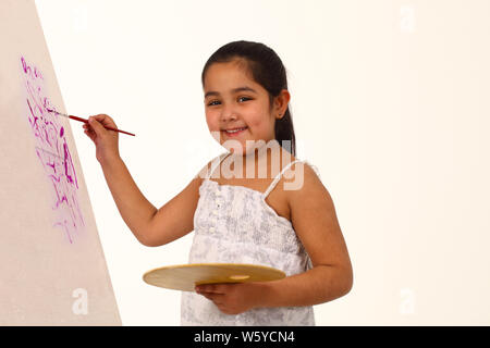 Mädchen malen an der Staffelei und lächelnd Stockfoto