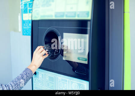 Käufer zurück, um ihre Flaschen und Dosen von wiederverwendbaren Verpackungen in einem umgekehrten Automaten. Stockfoto