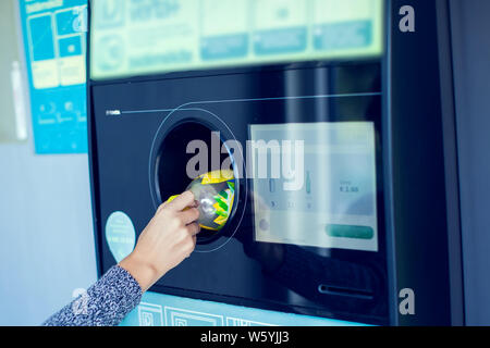 Käufer zurück, um ihre Flaschen und Dosen von wiederverwendbaren Verpackungen in einem umgekehrten Automaten. Stockfoto