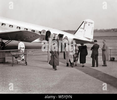 1930er Jahre anonym die Fluggäste eine kommerzielle TWA Flugzeug auf dem Rollfeld des Flughafens Newark NEW JERSEY USA - 163 HAR 001 HARS KUNDENSERVICE AUSSEN INNOVATIONSKRAFT TARMAC A AUF DER LUFTFAHRT NJ BERUFE VERBINDUNG KONZEPTIONELLER NEWARK STILVOLLEN NEW JERSEY TWA ANONYME FLUGHÄFEN ZUSAMMENARBEIT SCHWARZ UND WEISS KAUKASISCHEN ETHNIE HAR 001 ALTMODISCH Stockfoto