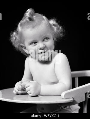 1940 LÄCHELNDE BLONDE BABY GIRL MIT TOP HAIR CURL KRAUSES SEITEN IM HOCHSTUHL SITZEN - b 19733 HAR 001 HARS HOME LEBEN KOPIEREN RAUM MIT HALBER LÄNGE VERTRAUEN AUSDRÜCKE B&W GLÜCK FRÖHLICH IN freudigen Lächeln konzeptionelle neugierig schüchtern STILVOLLE VORLÄUFIGE KRAUSES WACHSTUM HOCHSTUHL JUGENDLICHE SEITEN BABY GIRL SCHWARZ UND WEISS KAUKASISCHEN ETHNIE HAR 001 ALTMODISCH Stockfoto